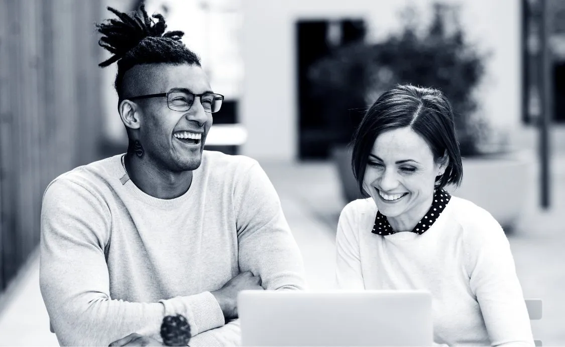Two happy people working on a laptop