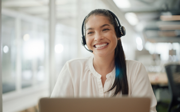 woman wearing headset at laptop with big smile woman wearing headset at laptop with big smile