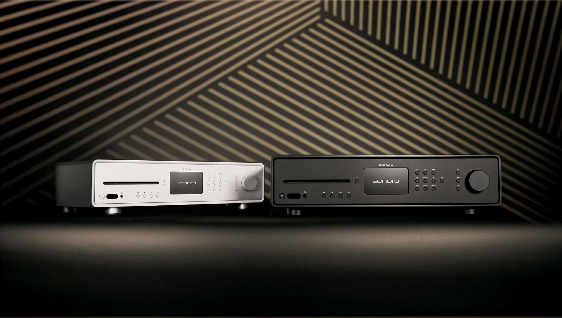 sonoro MAESTRO Audiosysteme in Schwarz und Weiß nebeneinander vor stilisiertem Hintergrund.